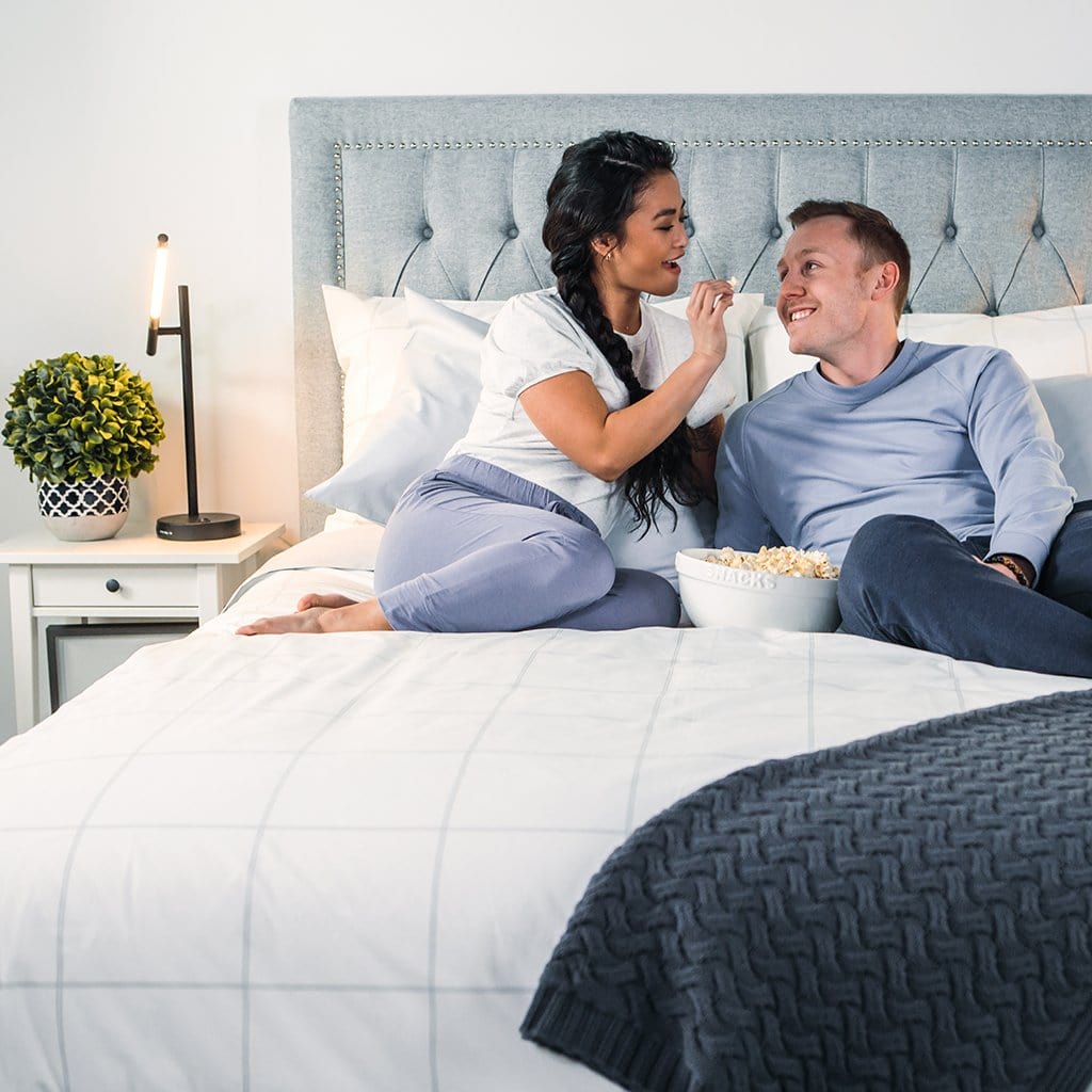 Man and Woman eating Popcorn on Light Grey Frame Percale Duvet