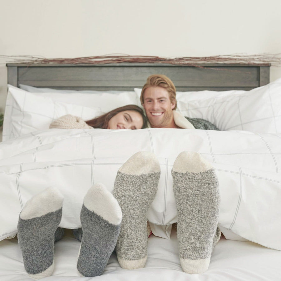 Man and Woman Laying under  Light Grey Percale Duvet with cozy socks