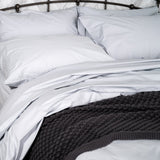 Bed Featuring Light Grey Duvet and Sheet Set
