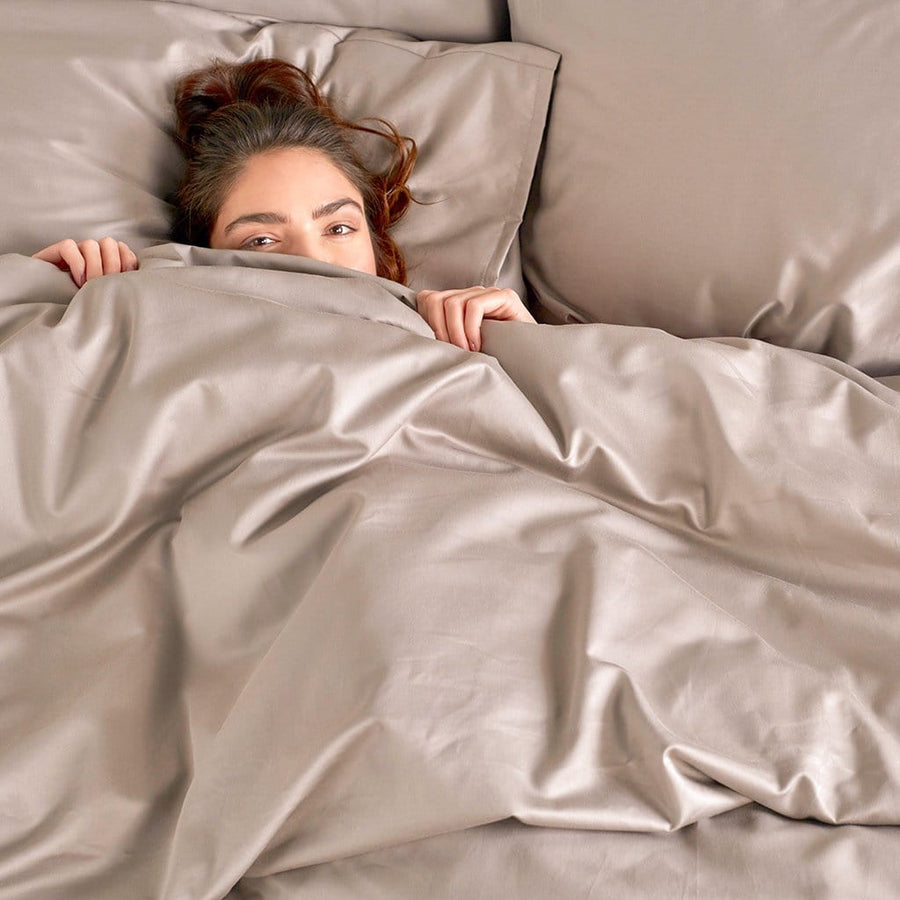 Woman Laying in Bed featuring Frosted Almond Refined Sateen Duvet Cover
